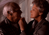An elderly man and woman share an affectionate moment indoors, holding hands as soft light creates a warm atmosphere—reminiscent of scenes from the Best Friends for Life (1998) DVD.