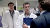 Two male doctors in white coats, one with a blue clipboard, stand in a hospital hallway listening to a man in a suit—just like a scene from Bloodlines (2010) DVD, a rare find for true crime enthusiasts.