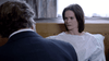 A woman in a hospital gown sits up in bed, looking concerned at a man in a suit. The scene, reminiscent of rare films like Bloodlines (2010) DVD, unfolds amid patterned curtains and wooden furniture.