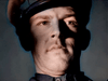 An iconic close-up of a stern man in uniform from Fear and Desire (1952)—half his face in shadow, half brightly lit—captured on this rare DVD edition.
