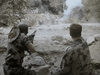 Two soldiers in camo take cover behind stone, one aiming a rifle as smoke rises—an intense scene reminiscent of Vietnam War action films like Hell on the Battleground (1988) DVD.