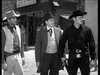 Three men in cowboy attire face off in an old Western town—one in a light vest and hat, one in a suit with bow tie, the third dressed in black with a gun—capturing the classic Western action of A Noose for a Gunman (1960) DVD.