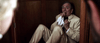 A man in a beige suit hides in a wooden closet, holding a white cloth to his mouth as ghostly figures open the door—echoing chilling scenes from the "Haunted Hotel (2021) DVD.