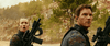 Two people in camouflage tactical gear and earpieces stand outdoors, one holding a large rifle. Trees and a rocky hill behind them evoke the intense action of The Tomorrow War (2021) DVD.
