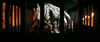 A large, grotesque alien-like creature with pale, textured skin stands menacingly behind bars in a fiery, dim setting—just like the monsters seen in The Tomorrow War (2021) DVD.