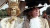 Two people in elaborate period costumes evoke Alexandre Dumas in The Man in the Iron Mask (1977) DVD—one with a gold crown, white outfit, and green face paint; the other with a large black hat and lace ruffles. They pose outdoors amid trees and drapery.