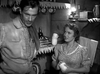 A man and woman in old-fashioned attire stand in a rustic kitchen with lantern light and shelves behind them, evoking classic Western drama. Product: The Westerner (1940) DVD.