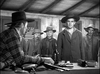 A tense Western scene unfolds as rugged men in hats confront a seated man with a shotgun and bottle, evoking classic drama reminiscent of Gary Cooper in The Westerner (1940) DVD.