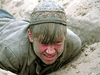 A young boy lies on the ground, his face partly covered by tousled blond hair and a patterned cap, evoking the emotion seen in Soviet war films like "Come and See (1995) DVD.