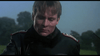 A man in a dark military jacket with shoulder patches looks down seriously outdoors, capturing the intense World War I air battle mood seen in the "Von Richthoften vs Brown (1971) DVD.