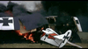 Two WWI-era biplanes with German insignia burn amid smoke on a grassy field, depicting the intense air battles featured in the Von Richthofen vs Brown (1971) DVD.