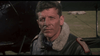 A man in a leather flight jacket with a fur collar stands by an old aircraft, capturing the thrilling spirit of WWI aerial combat depicted in Von Richthofen vs Brown (1971) DVD.
