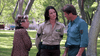 In a park, a woman in leopard print and curlers, a sheriff, and a man in teal have an intense discussion among the trees—echoing tense moments from creature horror films like "Razortooth (2006) DVD.
