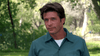 A brown-haired, blue-eyed man in a teal shirt stands outdoors among green trees. With a neutral look, he could star in a creature feature like the killer eel movie Razortooth (2006) DVD.
