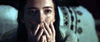 A distressed woman, tears streaming down her face as she covers her mouth with both hands, evokes the chilling atmosphere of a psychological horror film. A patterned blanket appears in the background. Product: The Night House (2020) DVD.
