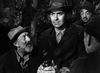 A scene from Nightmare Alley (1947) DVD shows four men outdoors in worn clothes and hats; one holds a bottle as another looks up, speaking to him. The tense black-and-white moment recalls classic film noir.