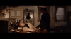 A man in a light suit slumps on a desk under a lamp, while another man in dark clothing stands beside him—a suspenseful office scene from the classic film "When Eight Bells Toll" (1971) DVD.