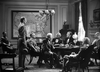 A group of men in 19th-century attire gather around a table by a U.S. map, resembling a scene from the classic film Virginia City (1940), available on DVD.