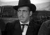 A man with a thin mustache in a dark suit, bow tie, and wide-brimmed hat gazes right with a serious look—evoking Errol Flynn in a classic Civil War scene. Blurred outdoor background. Product: Virginia City (1940) DVD.