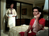 A woman in a red dress sits on a bed talking on a rotary phone, while another stands near the closet—evoking classic scenes from "Father Knows Best Reunion (1977)" DVD, with a patterned bedspread and mirrored closet doors.