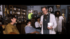In a vintage barbershop setting inspired by an Adam Sandler Western comedy, a man in a white coat holds a jar and brush while others look on—scene from "The Ridiculous 6 (2015) DVD.
