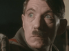 A light-skinned man with short brown hair and a small mustache, wearing a brown jacket, looks left with a tense expression—reminiscent of Ian McKellen as Hitler in the historical drama Countdown to War (1989) DVD.