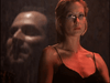 A serious woman in glasses and a black spaghetti-strap top stands under dramatic lighting with a faint man's face behind her, evoking true-crime drama tension in the cover of Obsessed (2002) DVD.