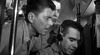 Three men in military uniforms, one with headphones, concentrate on radio equipment inside a WWII submarine scene. This black-and-white image reflects the tension in "Hellcats of the Navy (1957)" DVD.