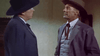 Two men in suits and wide-brimmed hats face off indoors in a western setting on the cover of The Bounty Hunter (1954) DVD—one in a dark suit and hat, the other in a gray suit with vest, tie, and light brown hat.