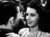 A black-and-white scene from "Stage Door Canteen (1943) DVD" shows a young woman with dark hair warmly smiling at a man as they dance closely, capturing the classic movie's heartfelt charm.