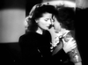 Two women dressed in vintage black-and-white attire stand together in a close embrace, capturing the emotional connection seen in classic films like Stage Door Canteen (1943) on DVD.