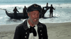 A bearded man in nautical attire stands on a beach, speaking, with four others near a beached boat—reminiscent of scenes from the rare classic "Island of the Blue Dolphins (1964)" DVD.