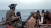 A group of people in historical clothing sit in a wooden rowboat on the sea, evoking tense scenes from rare classics like Island of the Blue Dolphins (1964) DVD.