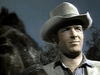 A man in a light cowboy hat and collared shirt stands outdoors by a dark horse, reminiscent of 1970s frontier films like "Gone with the West (1975) DVD," with trees and clear sky in the background.