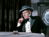 An elderly man in 19th-century attire with a wide-brimmed hat sits at a table with cash, reminiscent of classic cowboy films like "The Lone Gun (1954)" DVD, set before dark drapes and a prominent clock.
