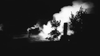 A black and white image evokes the tension of a POW escape as seen in "Break to Freedom (1953)" on DVD, showing someone running near flames and smoke at night with trees and a tall structure in the background.