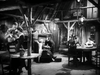 Black-and-white image of people in a rustic cabin, capturing the cozy, communal feel of 1935 westerns like The Fighting Westerner (1935) DVD—great for classic movie fans and collectors.