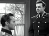 Two men in military uniforms talk in a room with a window—one seated, one standing—in this intense black-and-white WWII drama, "Under Fire (1957) DVD," a rare and hard-to-find movie.