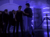 Four men outside a neon-lit building—two in black, one in a tuxedo and glasses, another casually dressed—chat by a blue velvet rope. Like a scene from the rare 80s vampire detective film, Nick Knight (1989) DVD.