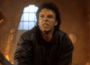 A man with dark, curly hair in a black jacket snarls in a dim room with a broken window—a striking scene from the rare Nick Knight (1989) DVD, an 80s vampire detective movie.