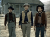 Three men in cowboy gear stand before a rustic wooden house on a dry, grassy landscape—a fitting visual for fans of the "Gun Belt (1953) DVD" and classic western cinema.