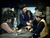 Four men in cowboy hats and western attire gather around a wooden table indoors, evoking classic scenes from the "Gun Belt (1953) DVD." An oil lamp glows on the table, hinting at cowboy cinema in an old saloon or cabin.