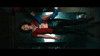 A woman in black pants and a red top with a chest tattoo lies on a metal table as someone in blue gloves holds her arm—a scene from "I'll Take Your Dead (2018)" DVD, evoking an unconventional Canadian horror thriller.