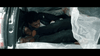 A tense, dimly lit scene from "I'll Take Your Dead (2018) DVD" shows a person curled up in a car trunk amid clear plastic sheets with another’s legs nearby, evoking the chilling mood of this unconventional Canadian horror thriller.