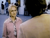 A woman in a light pink jacket stands outside facing a person with shoulder-length hair, while several people gather at ticket windows in the background—evoking the atmosphere of rare classic movies or a scene from a compulsive gambling drama like *Winner Take All (1975) DVD*.