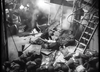 A black-and-white photo shows soldiers taking cover among debris and rubble, with smoke in the air and one person tending to another on the ground. A ladder and cables are visible amidst the chaotic scene, evoking the intense atmosphere of a British naval war drama like “Glory at Sea (1952)”—now available on DVD and reminiscent of classic WWII minesweeper movies.