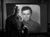 A man in uniform with an eye patch stands before a projected portrait—evoking the suspenseful WWII espionage atmosphere found in Operation Secret (1952) DVD.
