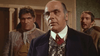 A man in a suit and cravat stands in the foreground, looking serious, with two men in rough clothing behind him inside a room—a compelling scene from Kill Johnny Ringo (1966) DVD, perfect for collectors of rare classic movies.
