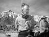A man with his hands tied behind his back sits on a horse with a noose around his neck, outdoors in a mountainous landscape. Another person on horseback appears in the background, capturing the tense drama of “Along the Great Divide (1951)” on DVD.