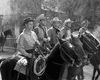 Five men wearing cowboy hats sit astride horses in a row outdoors, with trees and a wooden fence in the background. The black-and-white image evokes classic scenes from *Badman’s Country (1958)*—a perfect addition for collectors of western DVDs or anyone looking for rare movies like this one on DVD.